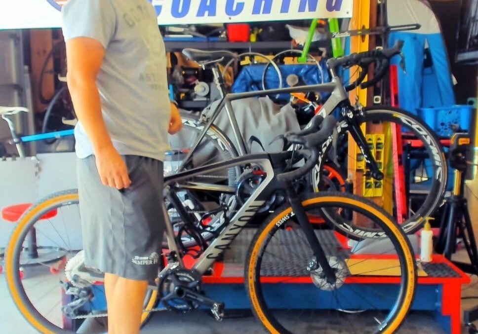 Person standing with a road bike