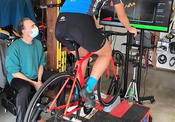 Woman cycling indoors with trainer guidance