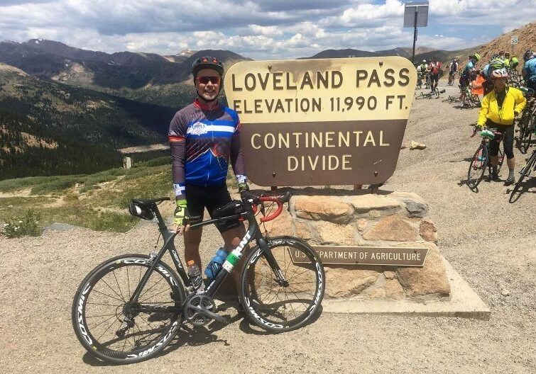 Biker posing with bicycle at mountain pass